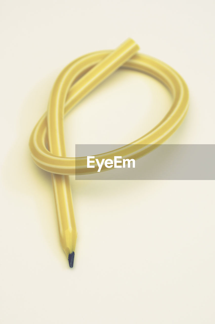 High angle view of yellow pencil on white background