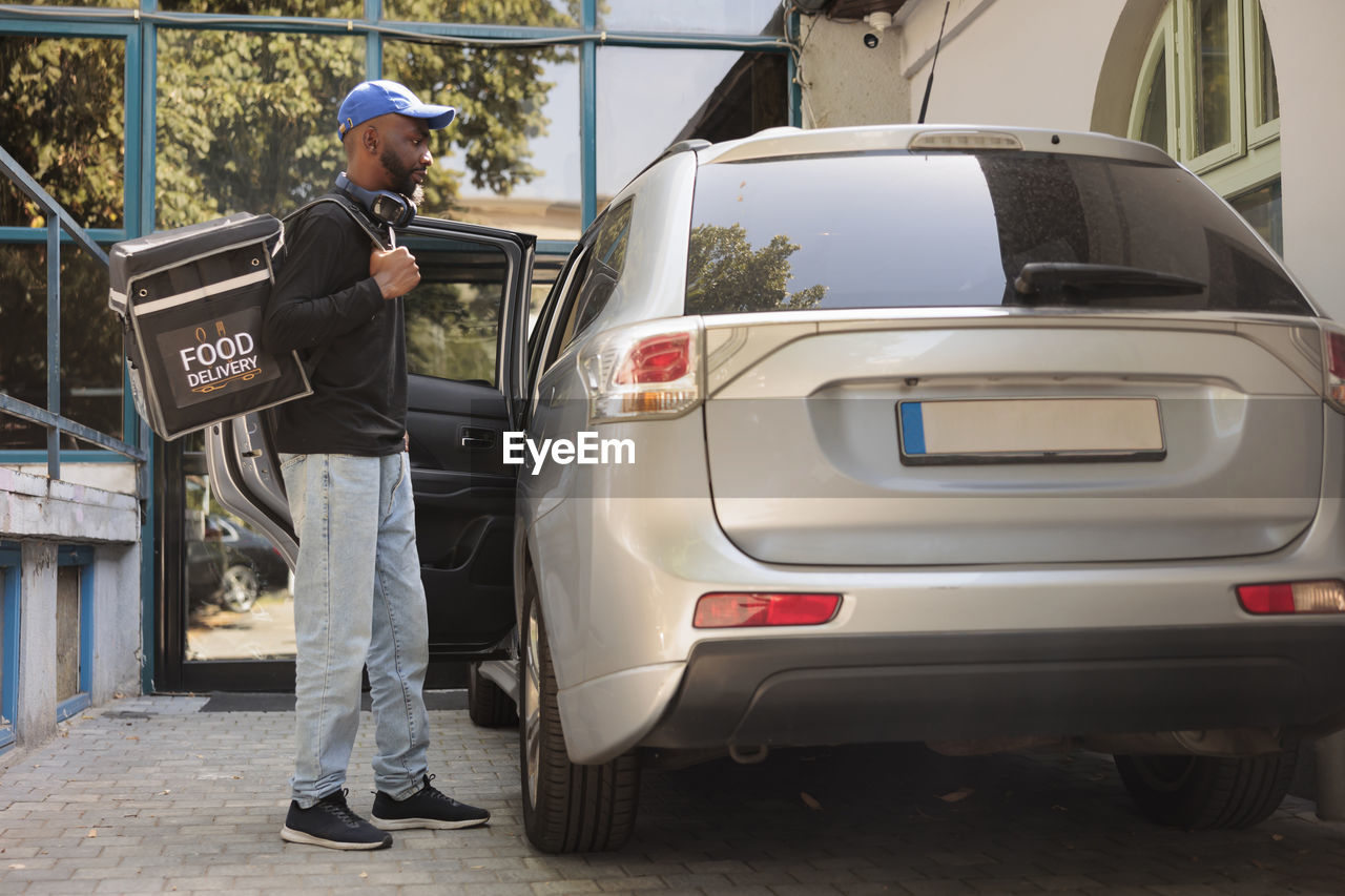 rear view of man using mobile phone while standing on street