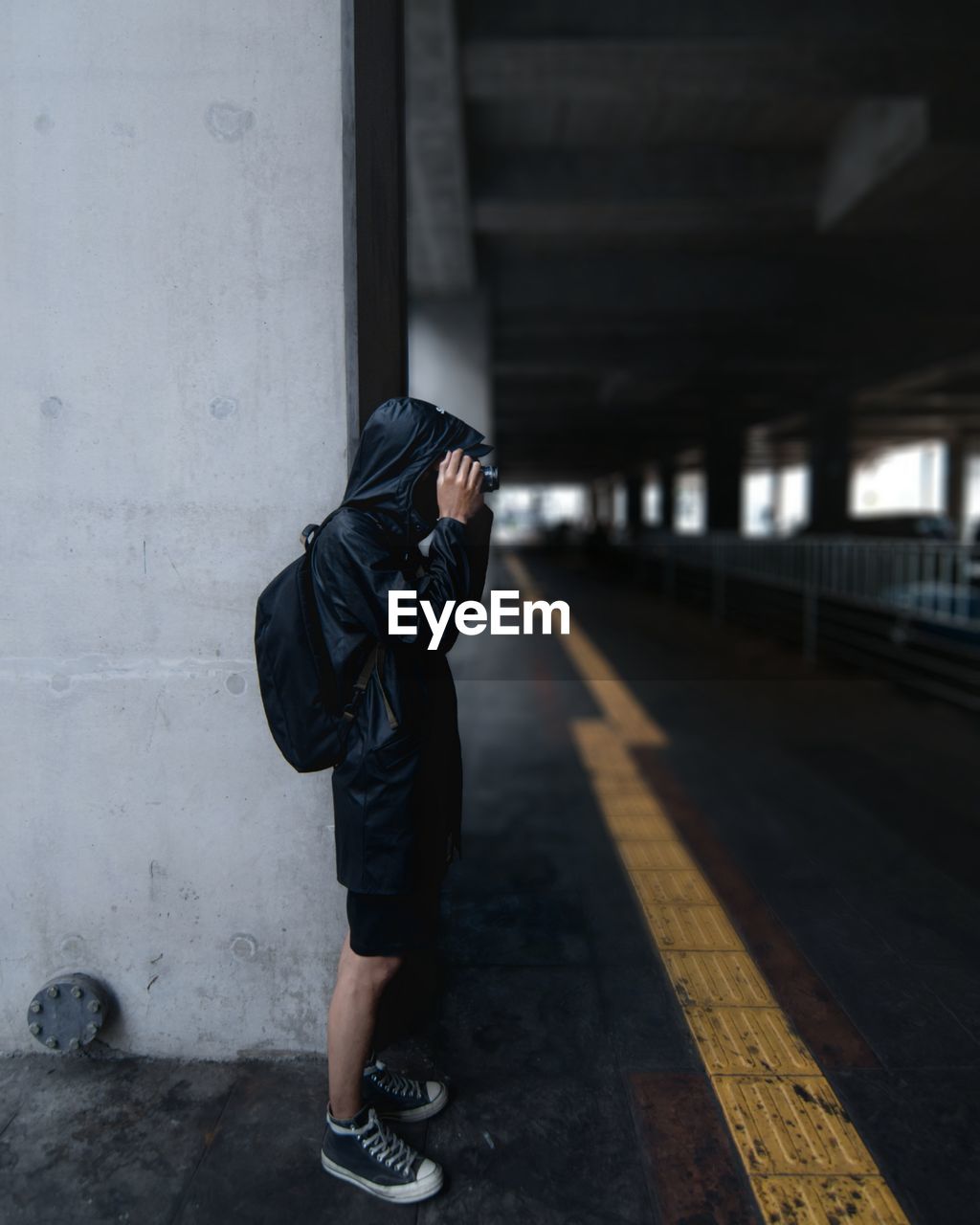 Full length of young man photographing in parking lot