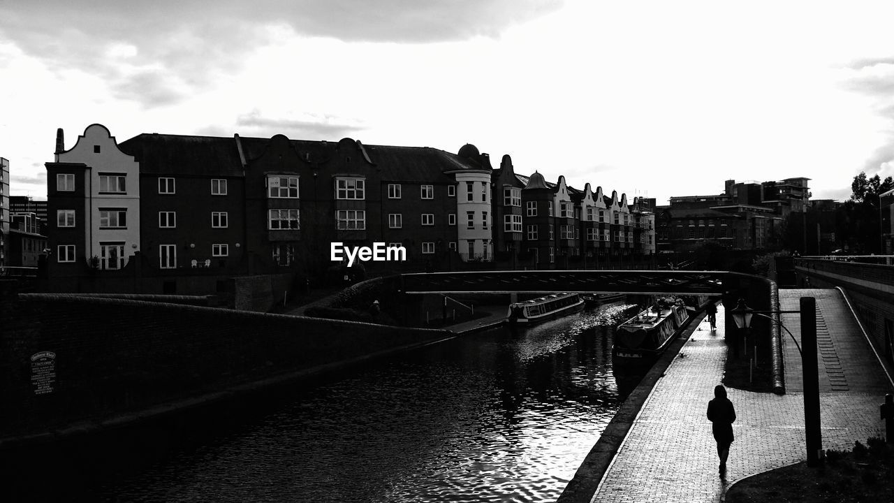 Bridge over canal against buildings