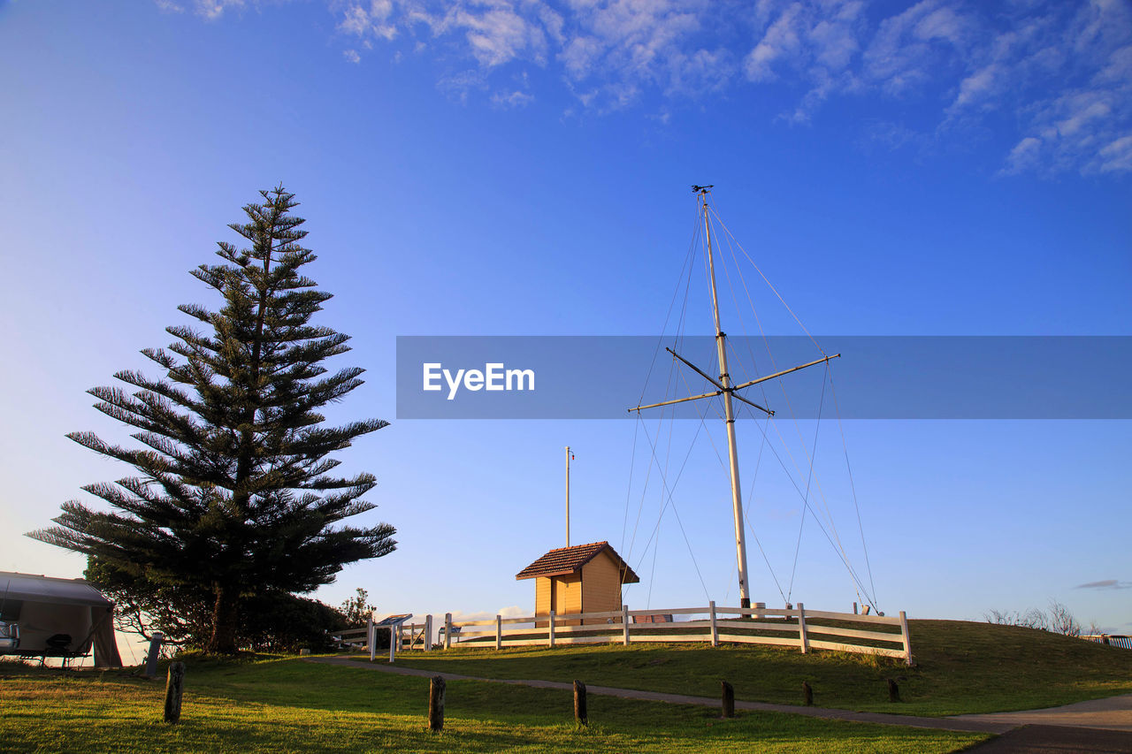 sky, architecture, windmill, environment, nature, environmental conservation, built structure, renewable energy, wind power, wind turbine, landscape, blue, plant, turbine, tree, alternative energy, power generation, grass, no people, building, rural scene, building exterior, wind, land, outdoors, travel destinations, house, beauty in nature, cloud, travel, field, technology, day, transportation, tower, mill, scenics - nature, clear sky