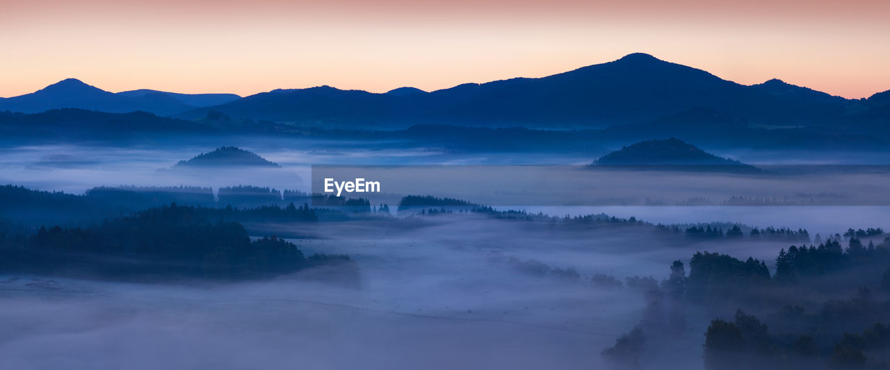 SCENIC VIEW OF MOUNTAINS AGAINST SKY AT SUNSET