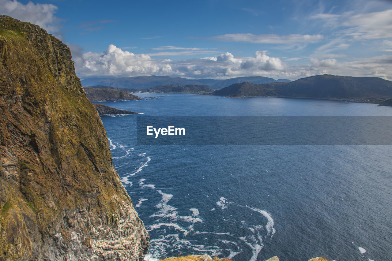 Scenic view of sea and mountains against sky