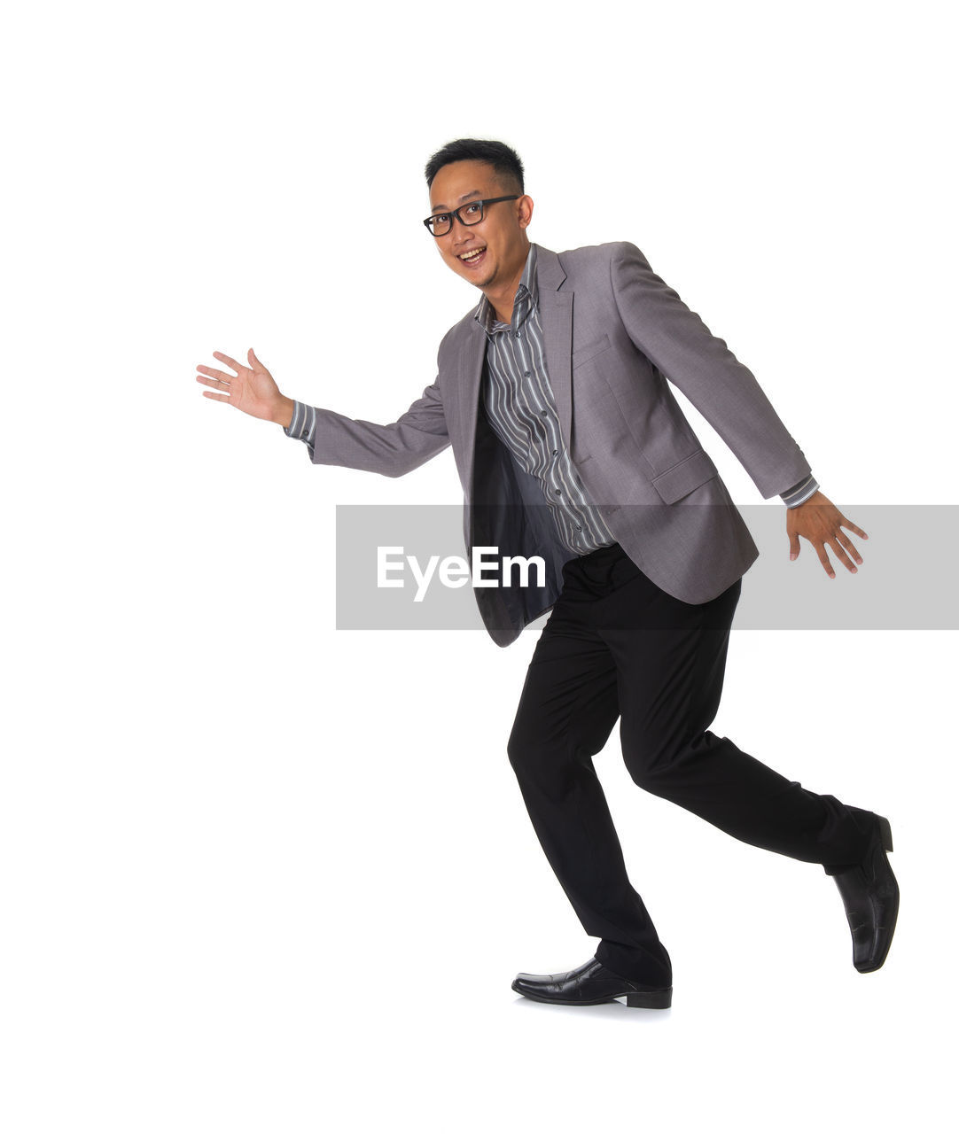 Portrait of smiling young man running against white background