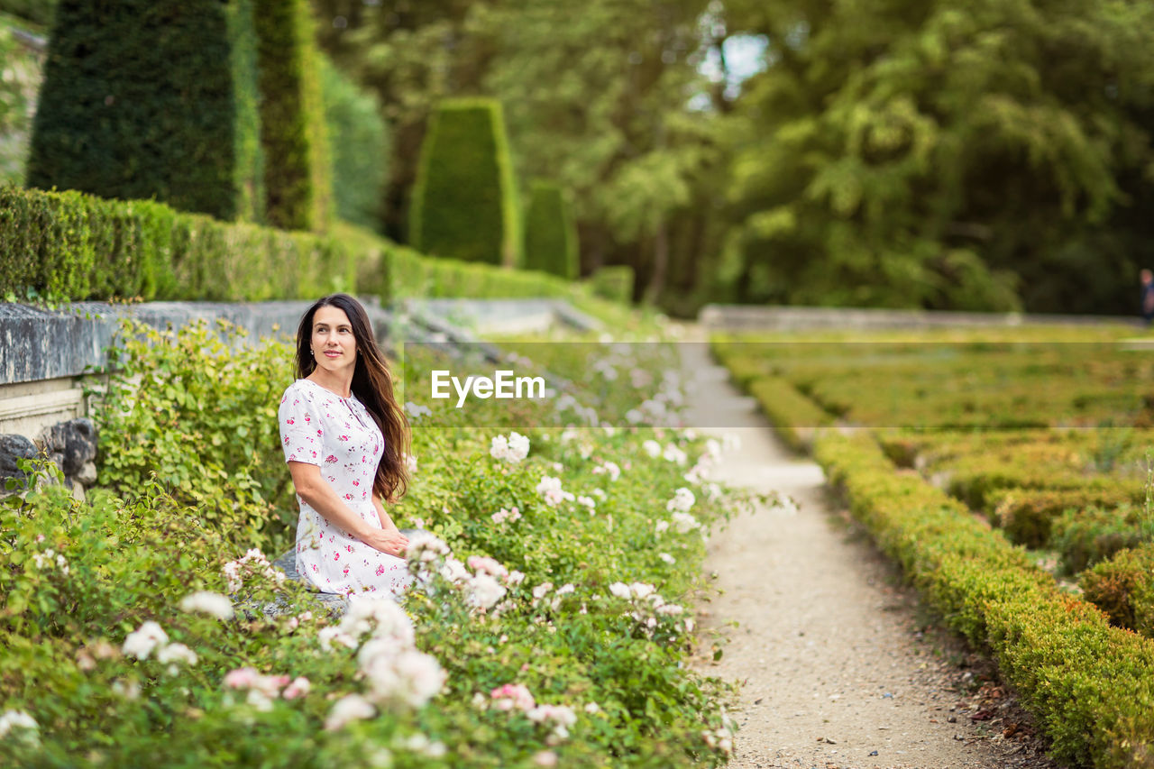 portrait of young woman standing on grassy field