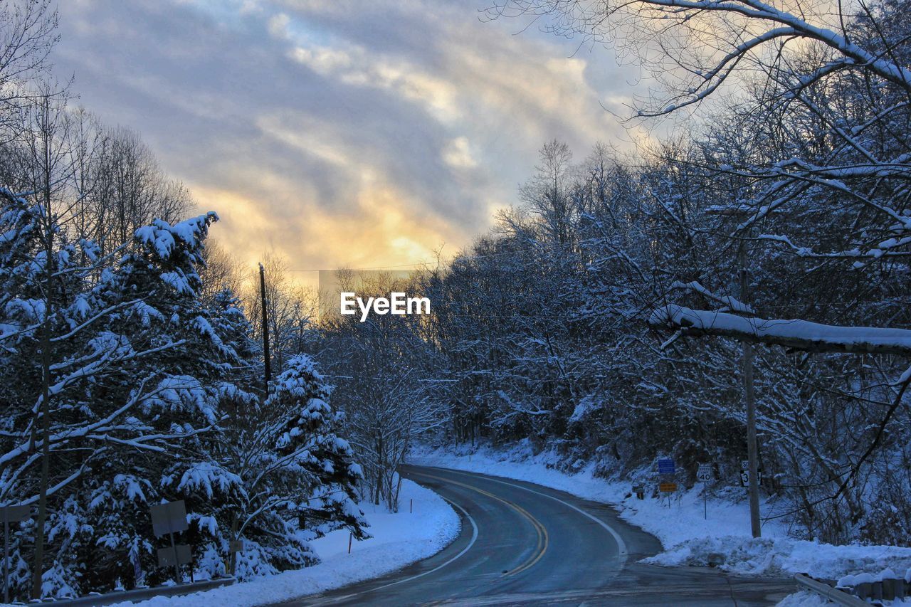 Snow covered landscape against cloudy sky