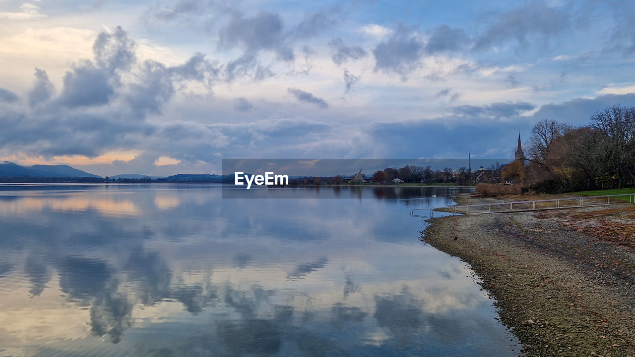 water, reflection, sky, morning, cloud, river, nature, body of water, scenics - nature, environment, beauty in nature, shore, landscape, reservoir, tranquility, dawn, land, tranquil scene, travel destinations, no people, travel, mountain, horizon, tree, outdoors, sunrise, beach, plant, tourism, blue, architecture, twilight, idyllic, coast, lagoon