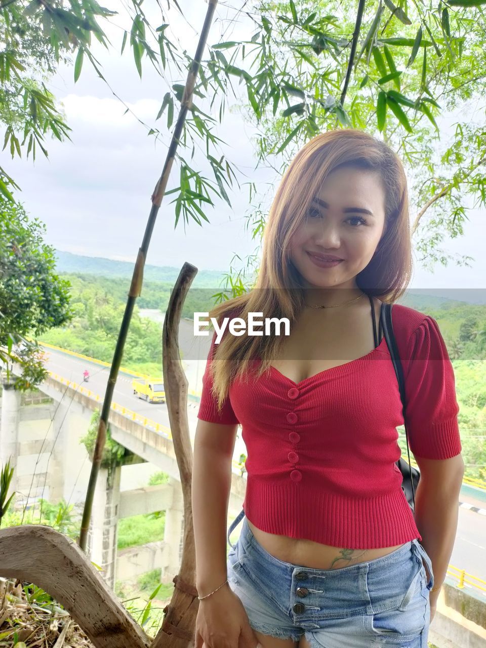 PORTRAIT OF BEAUTIFUL WOMAN STANDING AGAINST TREES