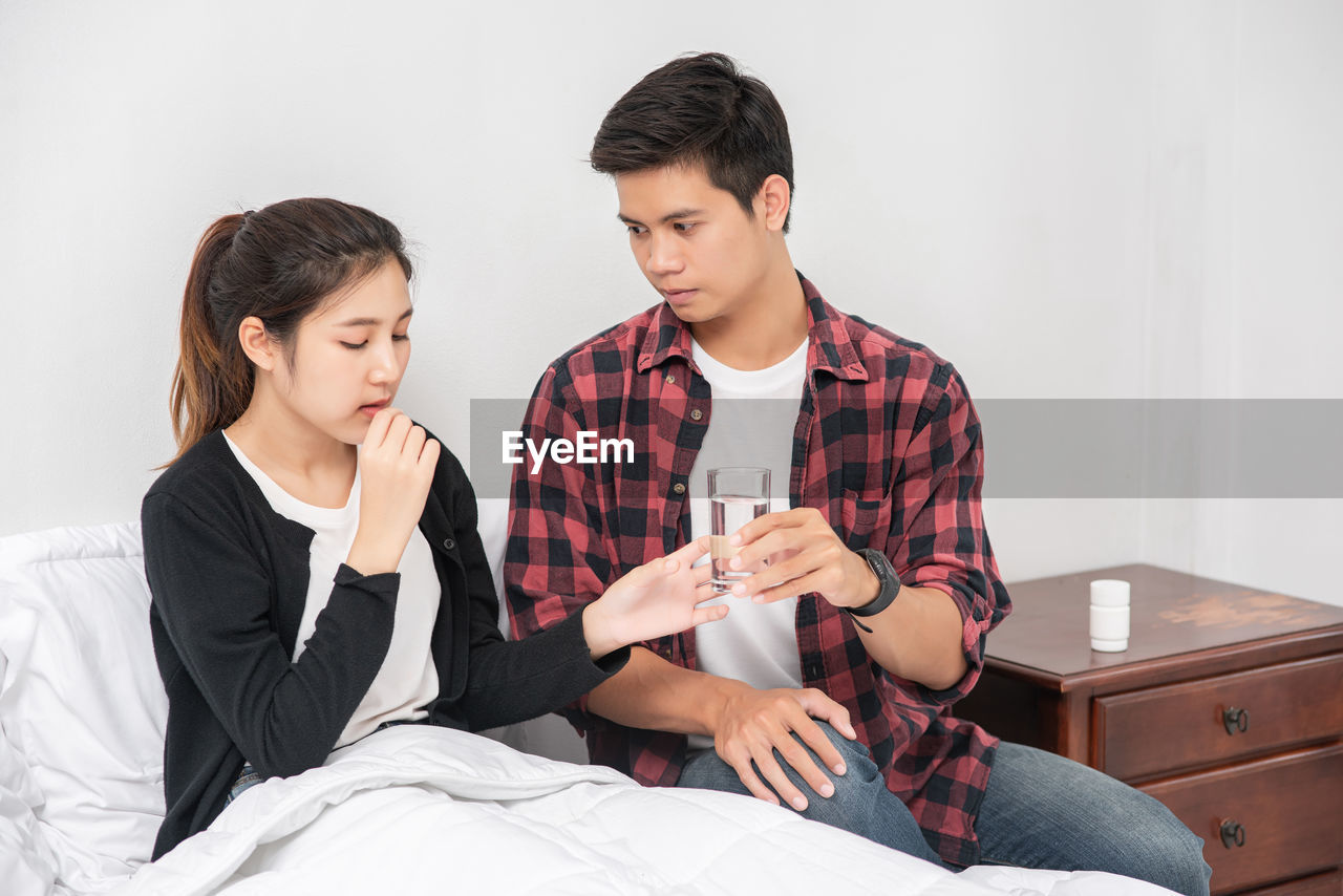 YOUNG COUPLE SITTING IN BED