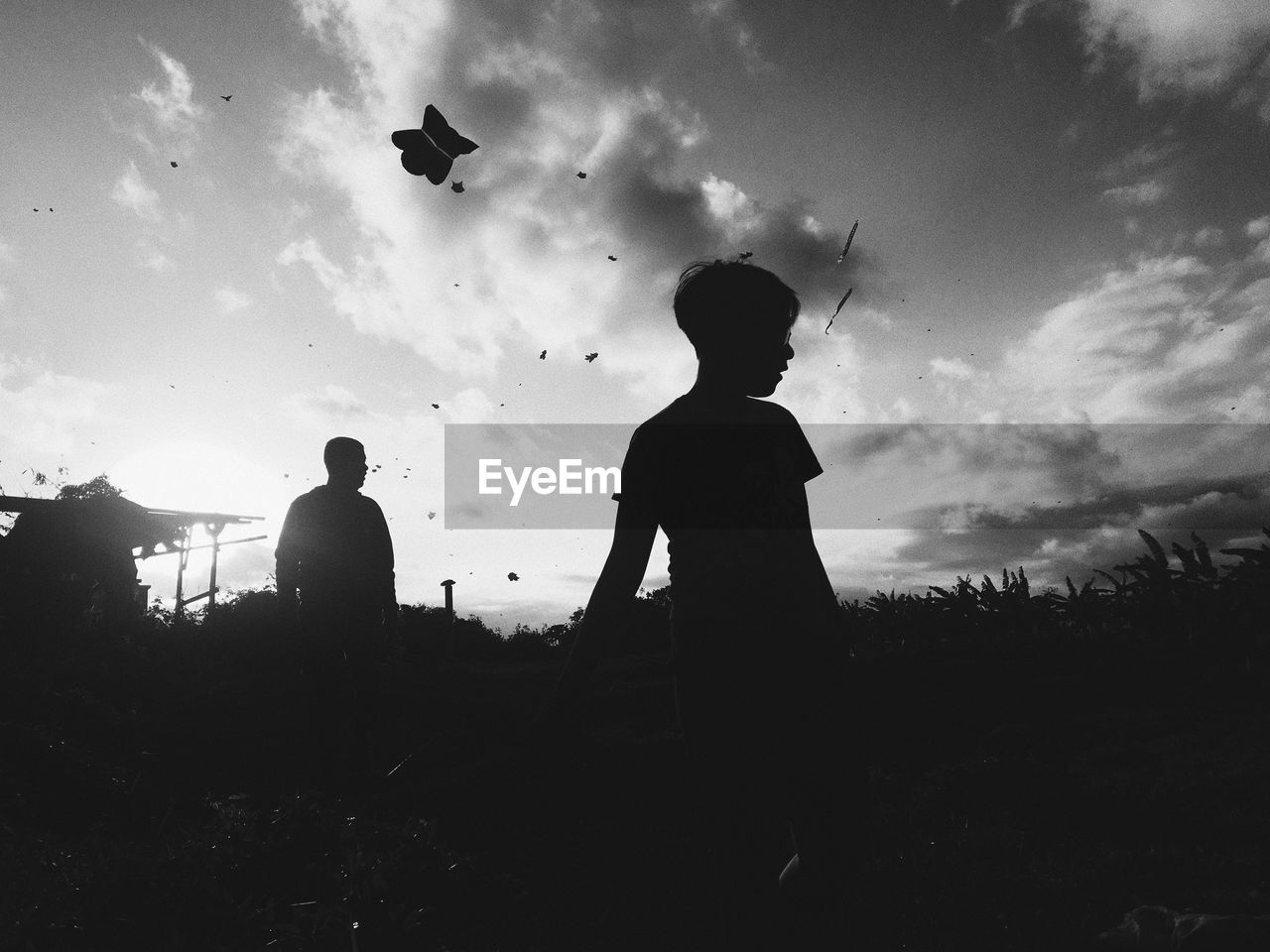 Silhouette people standing on field against sky