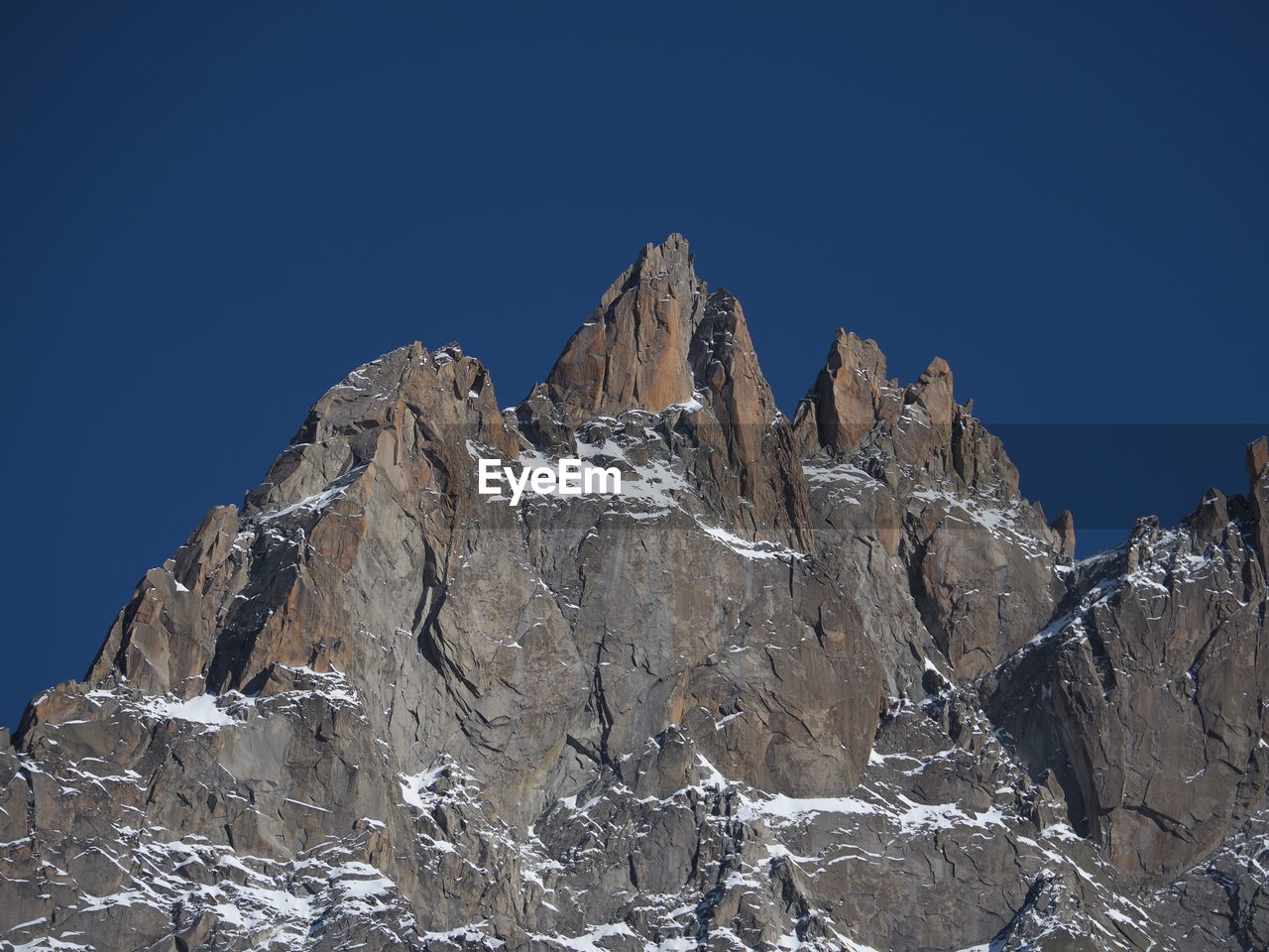 LOW ANGLE VIEW OF SNOWCAPPED MOUNTAINS AGAINST BLUE SKY