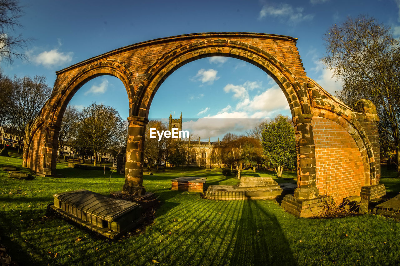 Arch wall in cemetery at stoke minster against sky