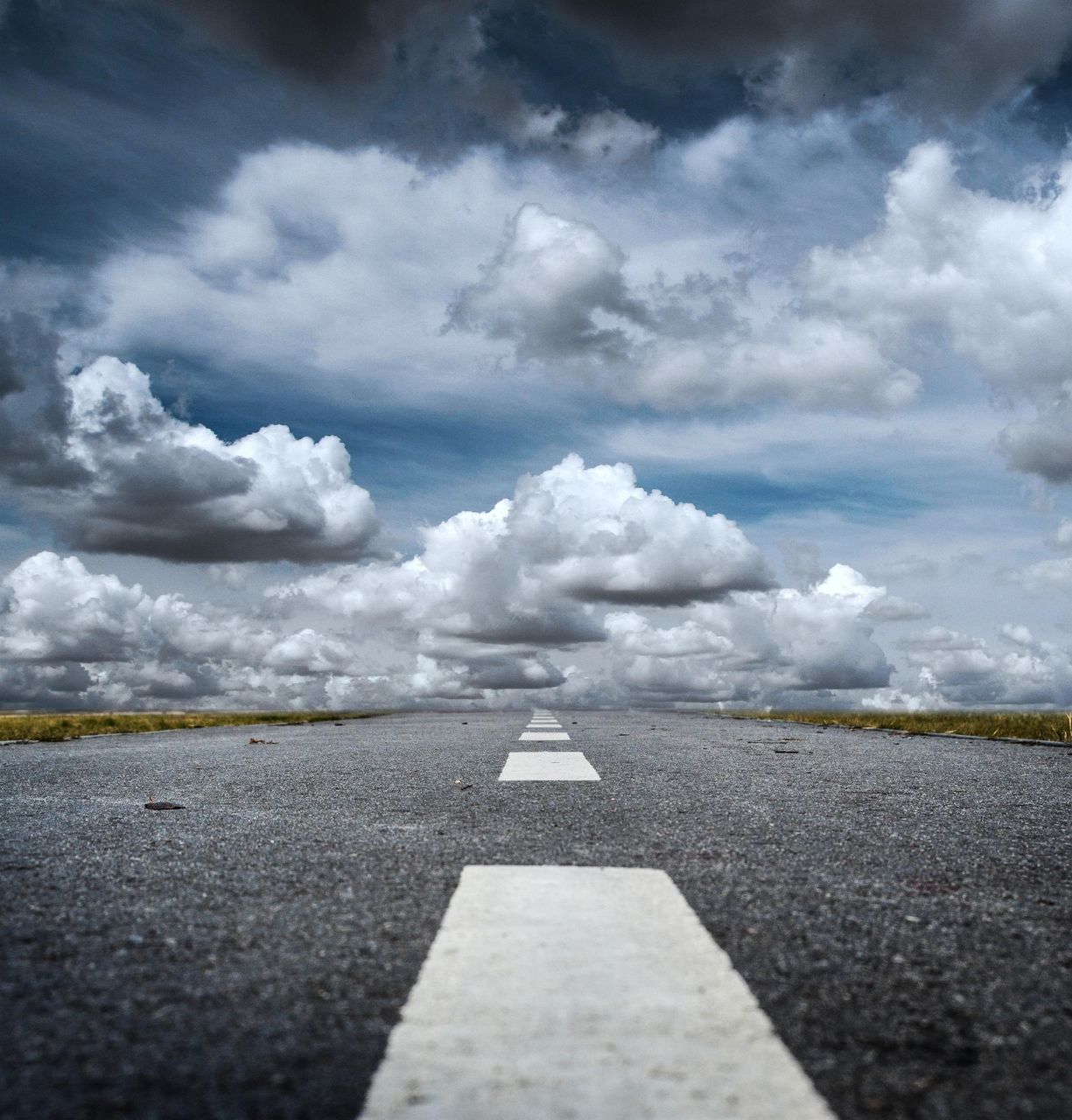 cloud, sky, horizon, road, sign, sunlight, transportation, symbol, sea, road marking, nature, no people, marking, the way forward, environment, day, asphalt, cloudscape, outdoors, white, beauty in nature, reflection, scenics - nature, storm cloud, landscape, travel, dramatic sky, storm