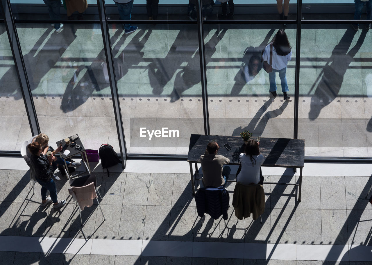 High angle view of people sitting at window in modern building