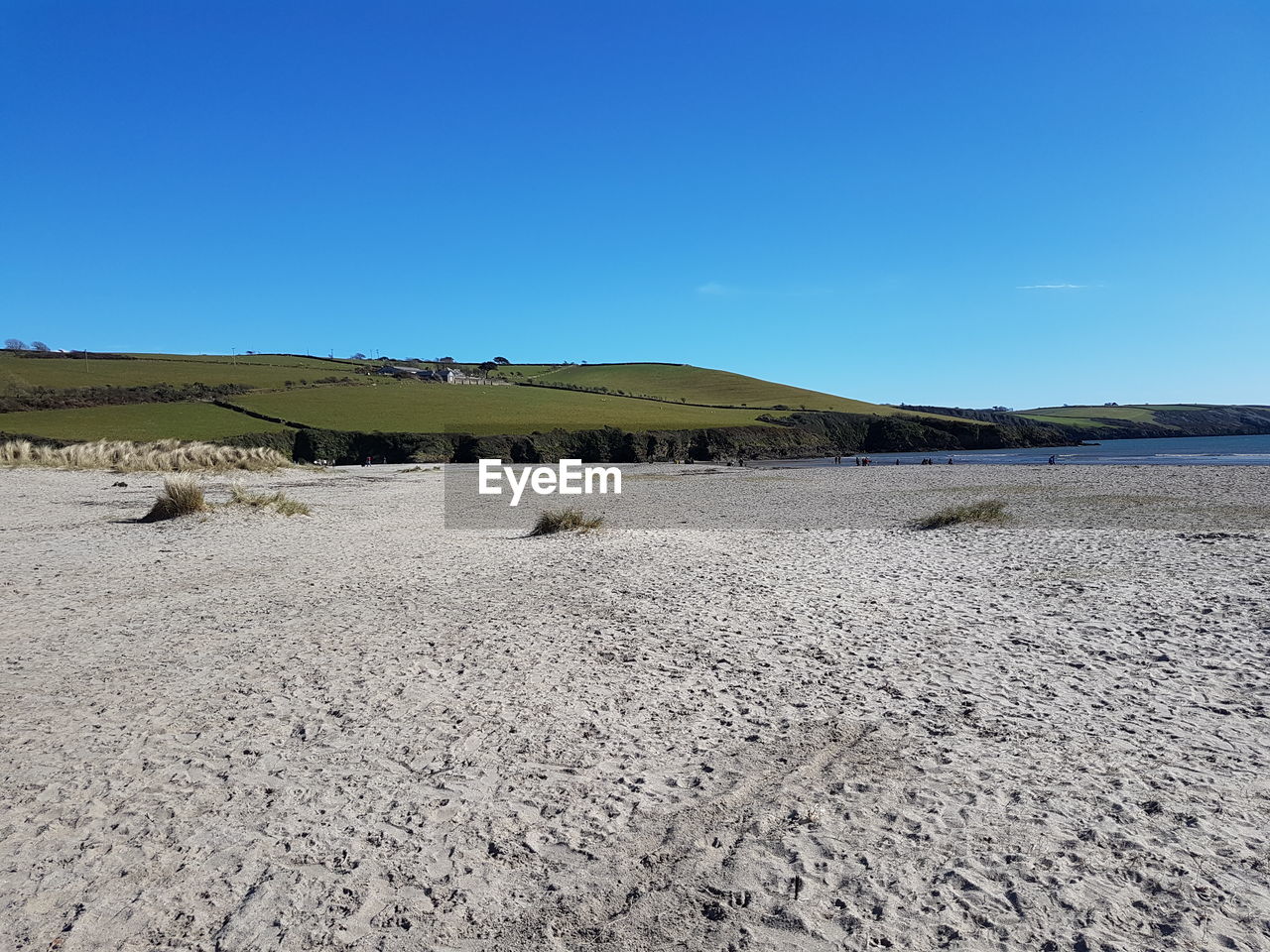 Scenic view of beach against clear blue sky