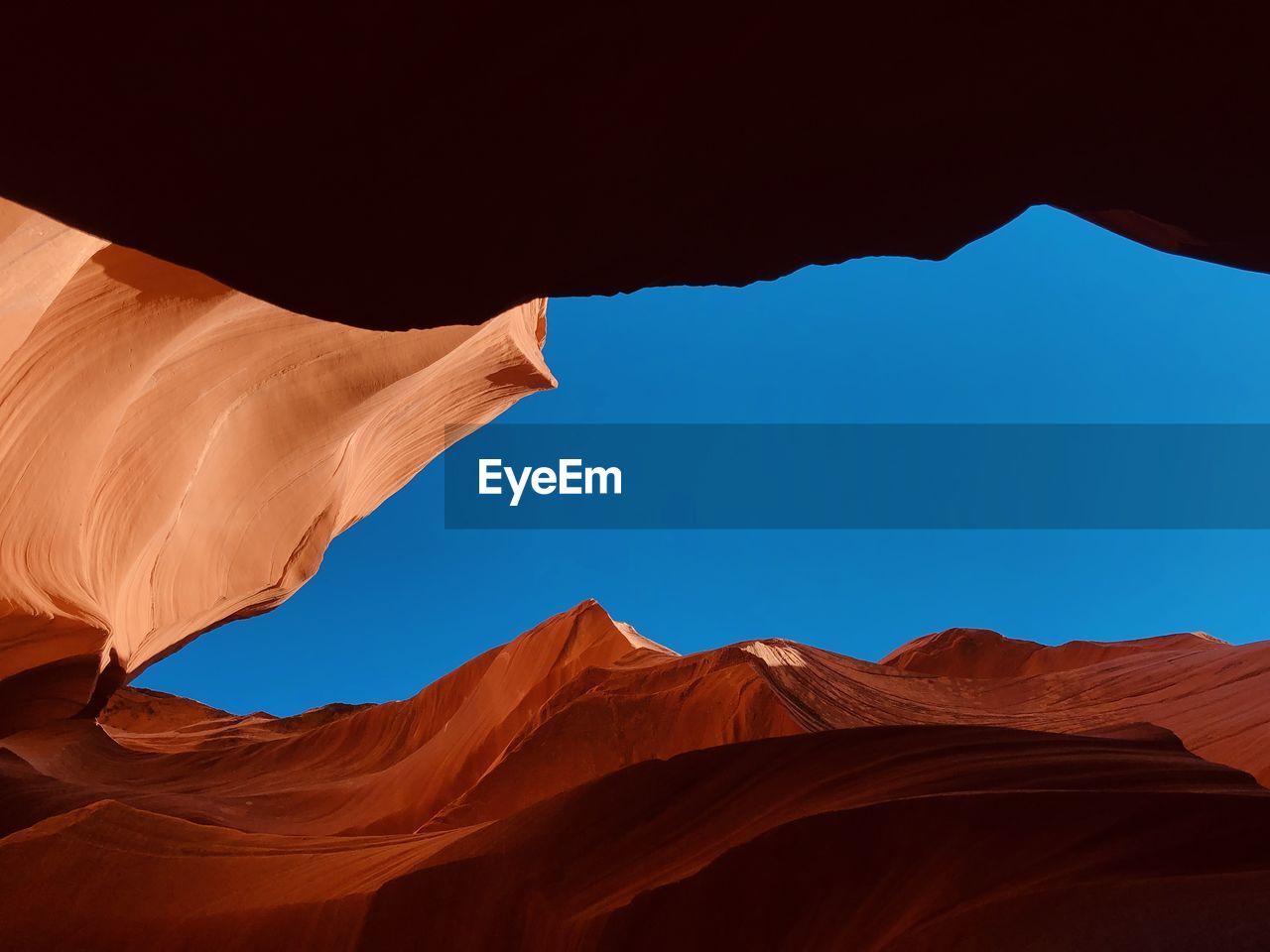 Low angle view of rock formations at desert against clear blue sky