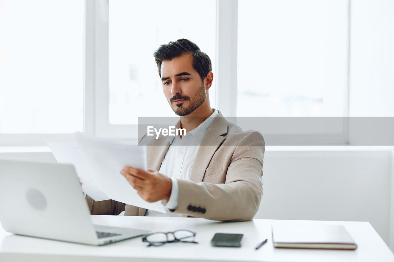 portrait of businessman using laptop at office