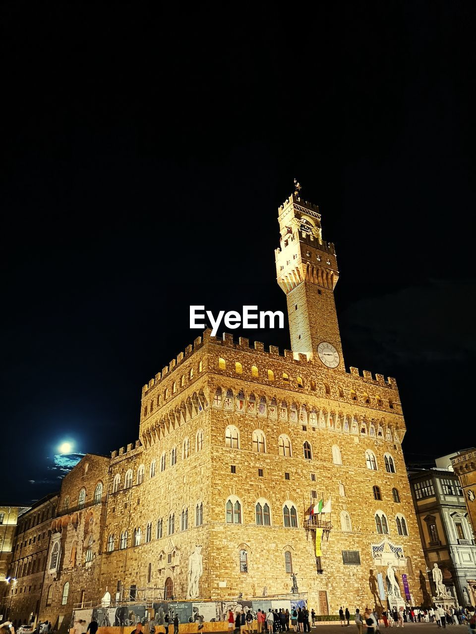 LOW ANGLE VIEW OF ILLUMINATED BUILDINGS AGAINST SKY AT NIGHT