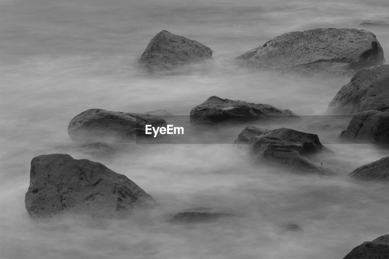 Scenic view of rocks in sea against sky