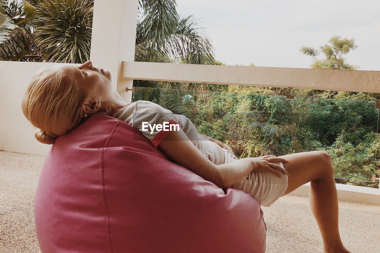 Woman relaxing on bean bag at building terrace