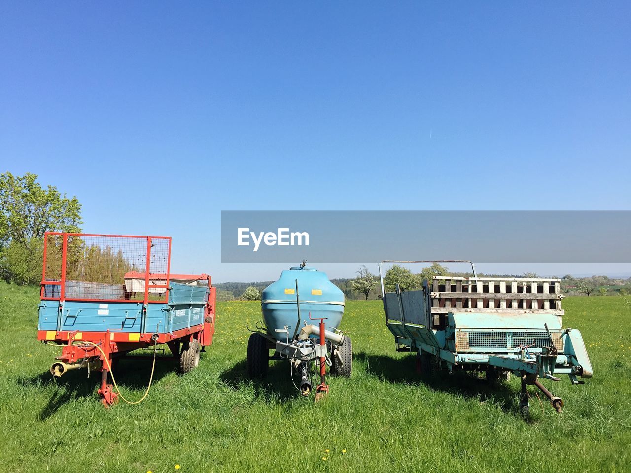 Agricultural machineries on field against clear sky