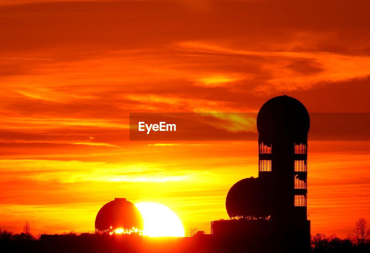 SILHOUETTE CROSS ON LAND AGAINST ORANGE SKY