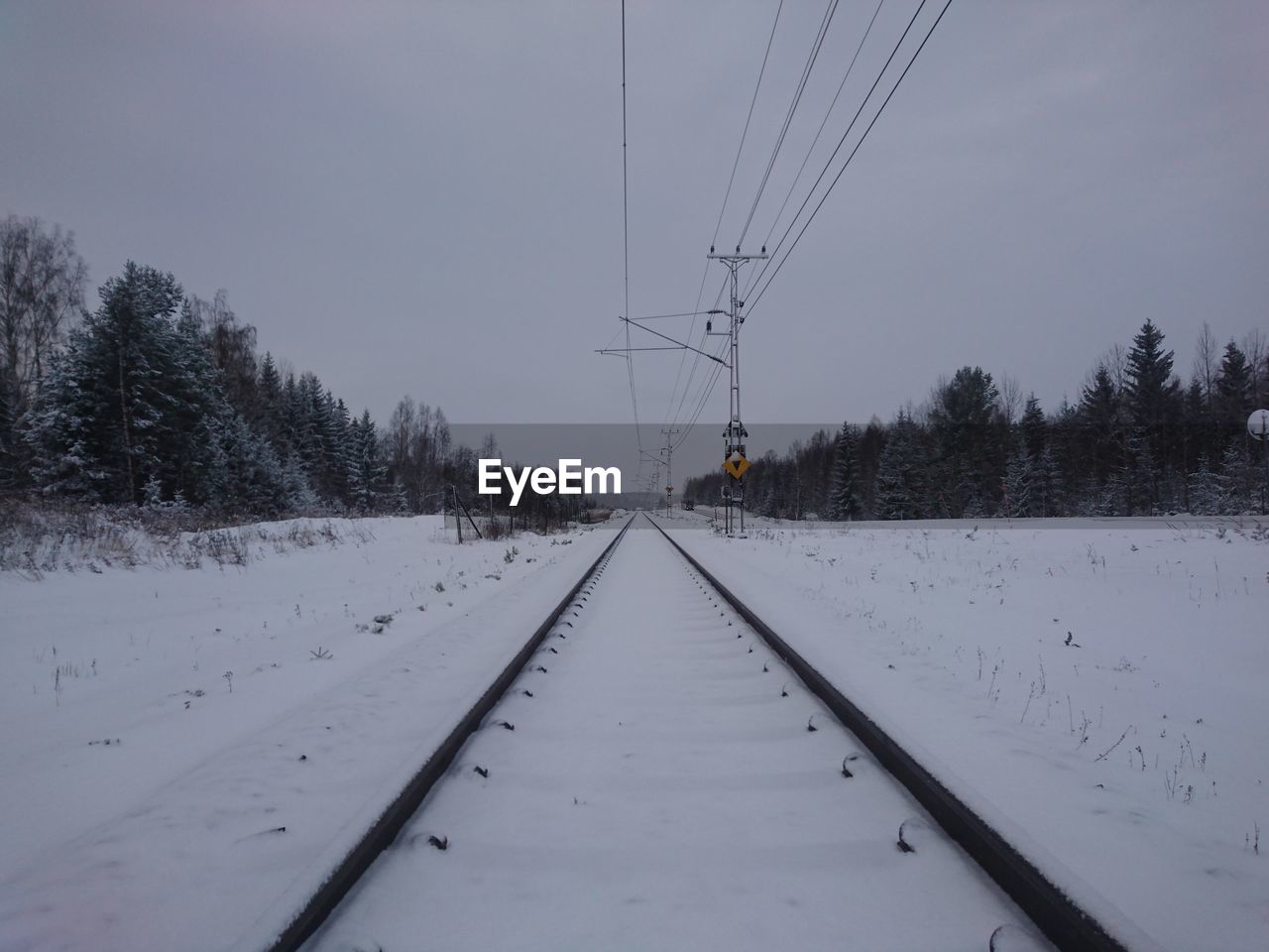 SNOW COVERED ROAD AGAINST SKY