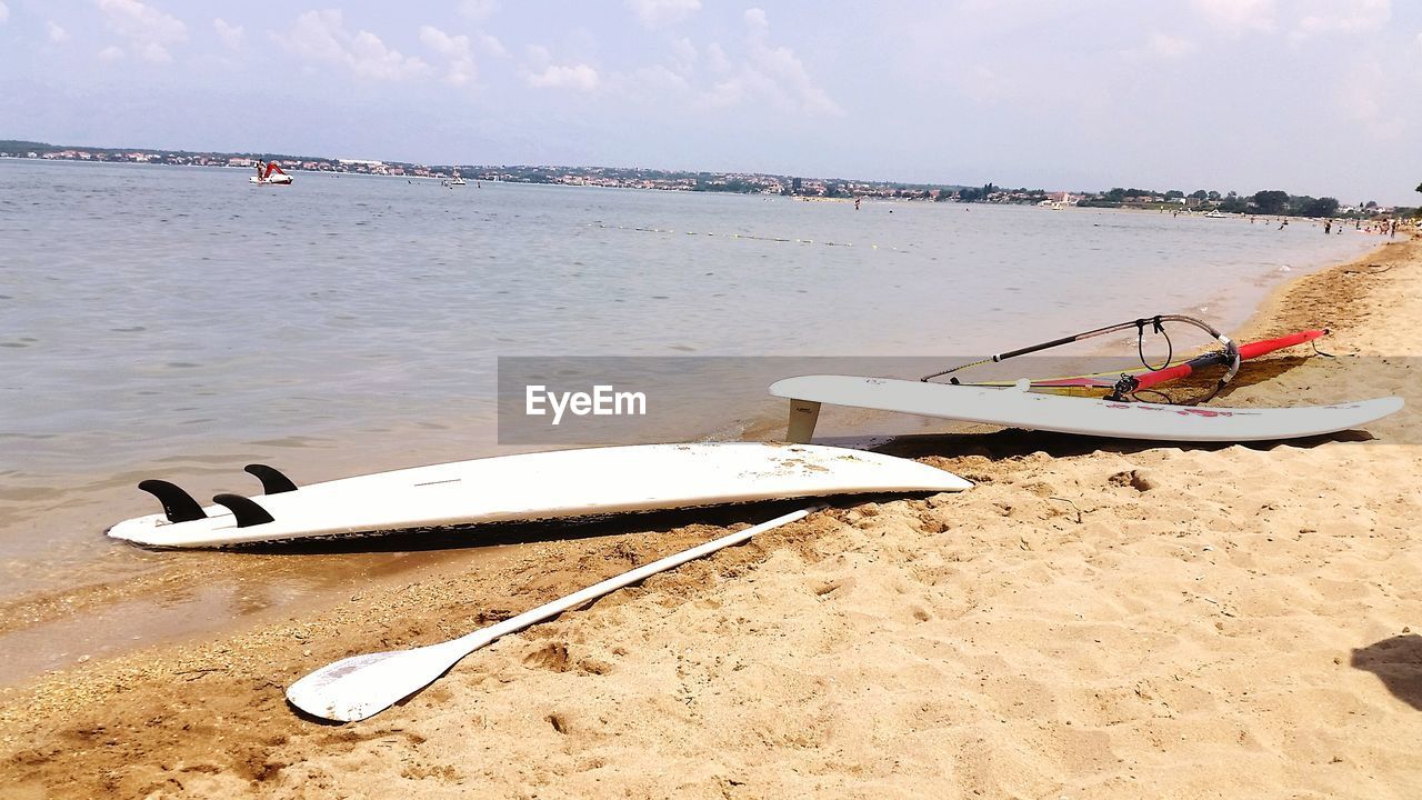 Boat moored on beach against sky