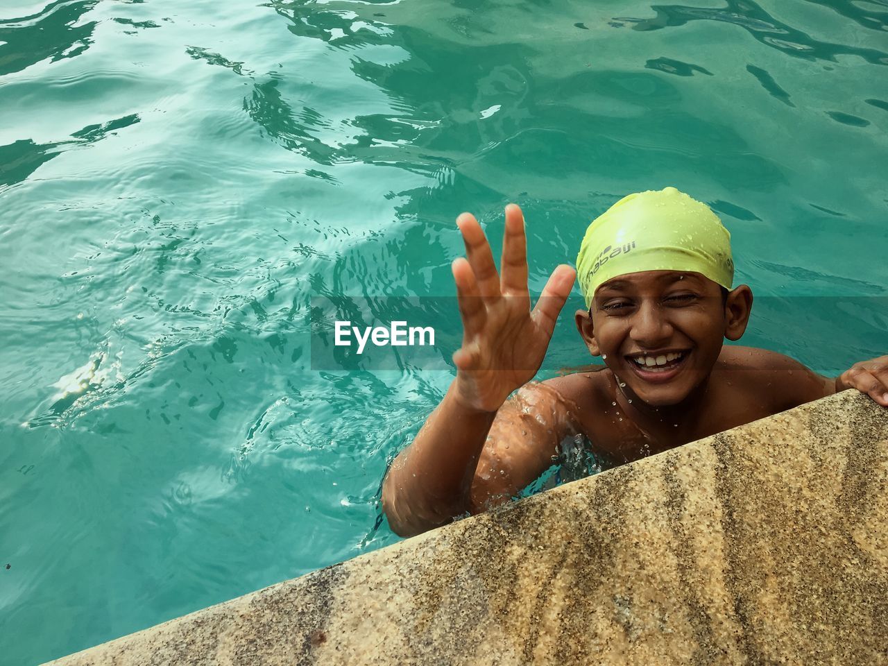 PORTRAIT OF A SMILING YOUNG WOMAN SWIMMING POOL