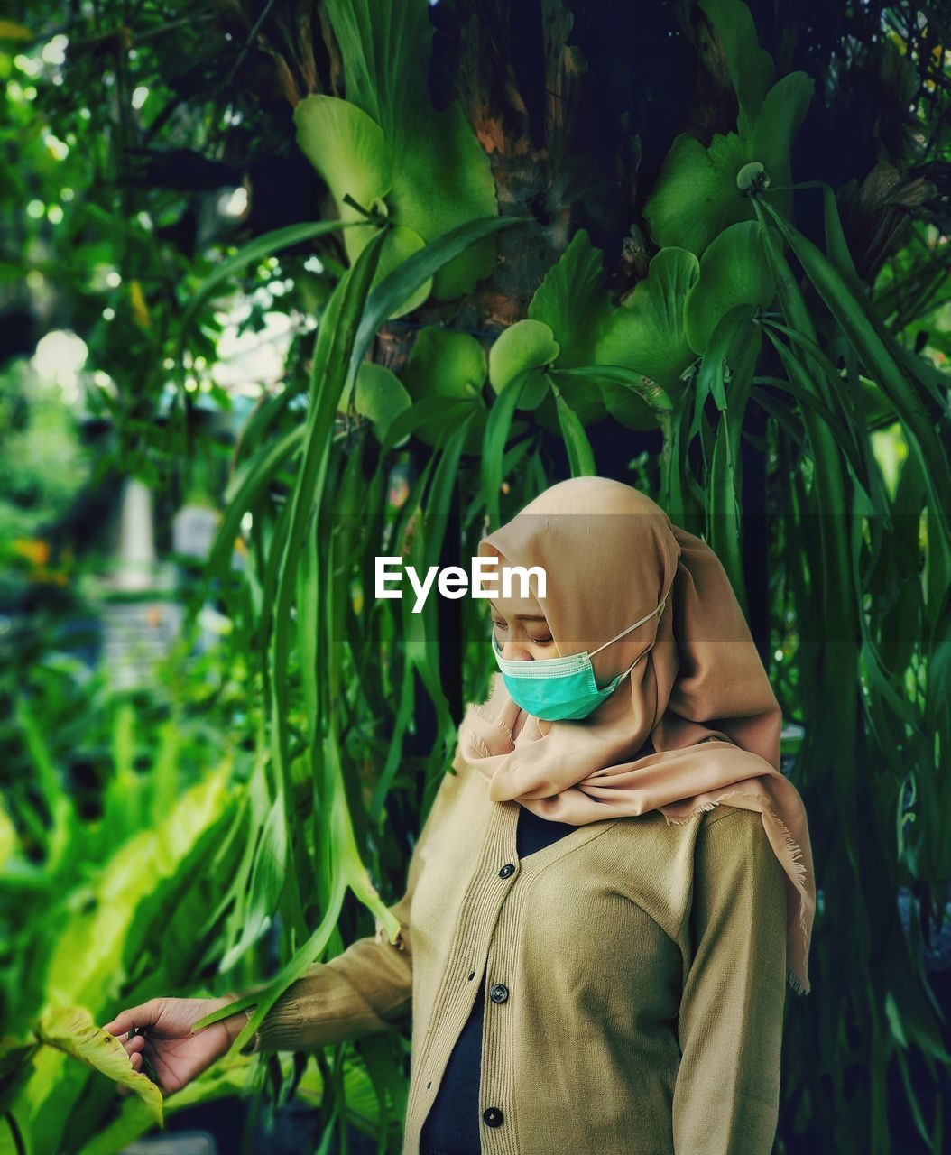 Portrait of man wearing sunglasses standing against plants