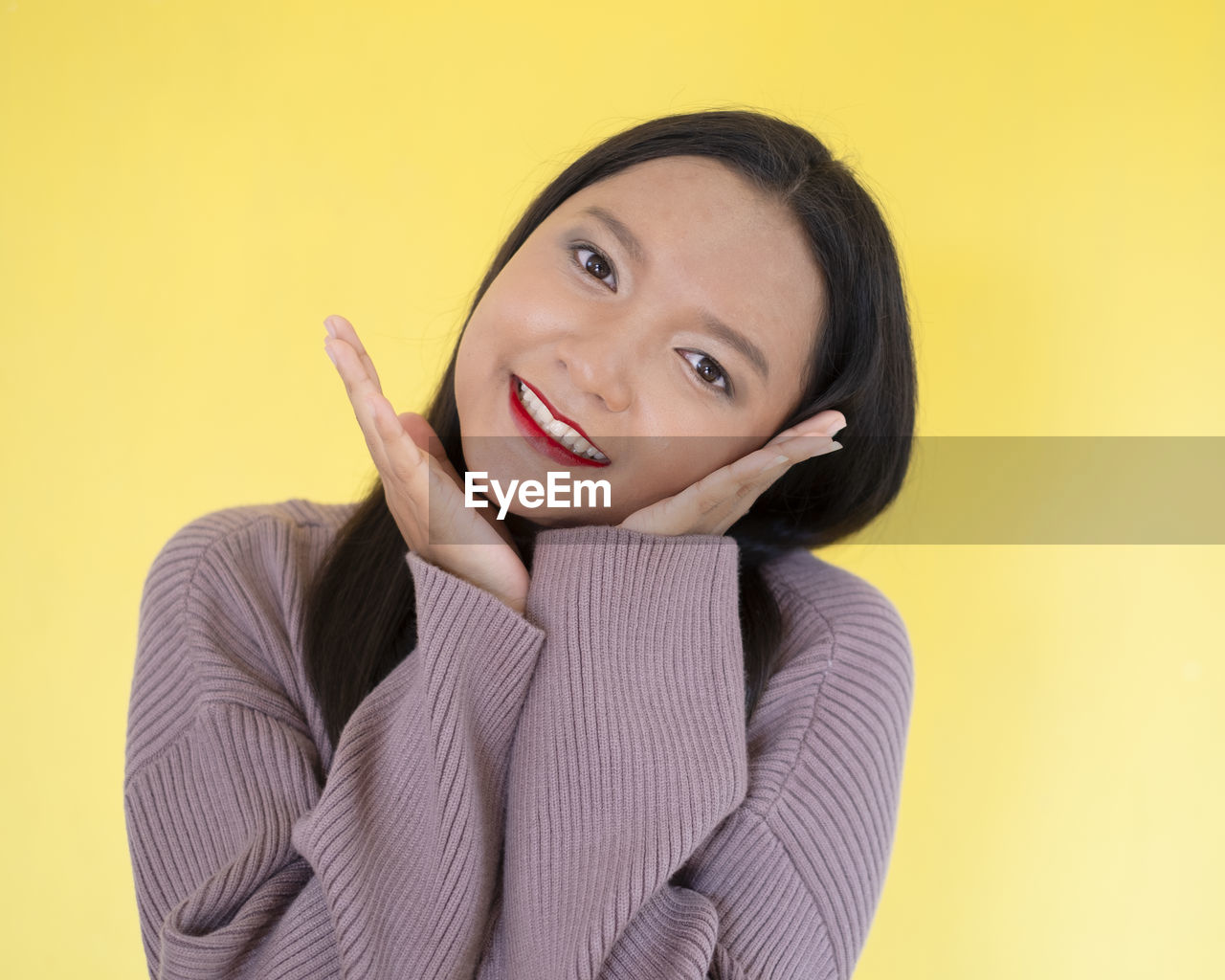 PORTRAIT OF SMILING YOUNG WOMAN AGAINST YELLOW BACKGROUND