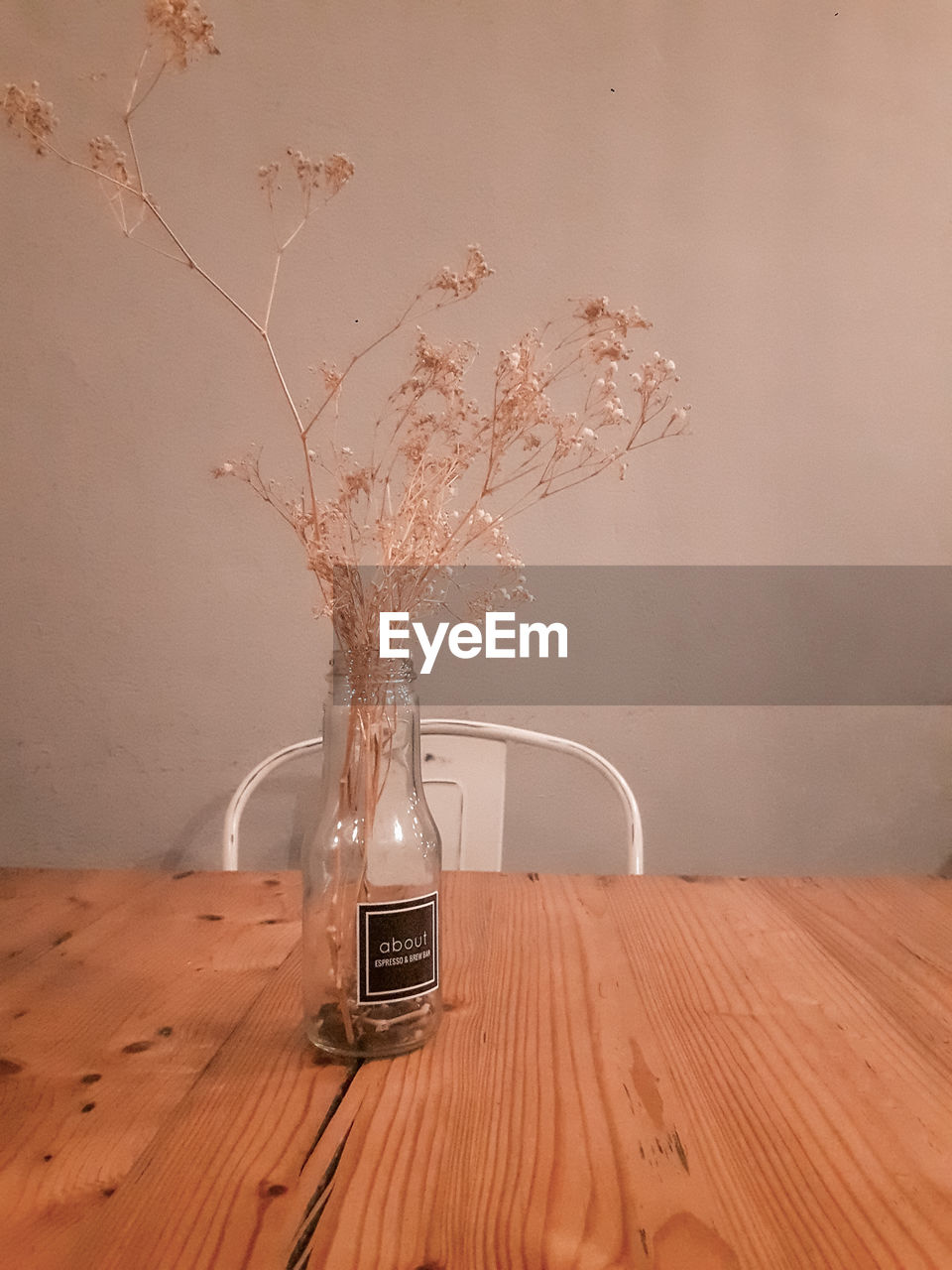 CLOSE-UP OF WINEGLASS ON TABLE AGAINST WALL