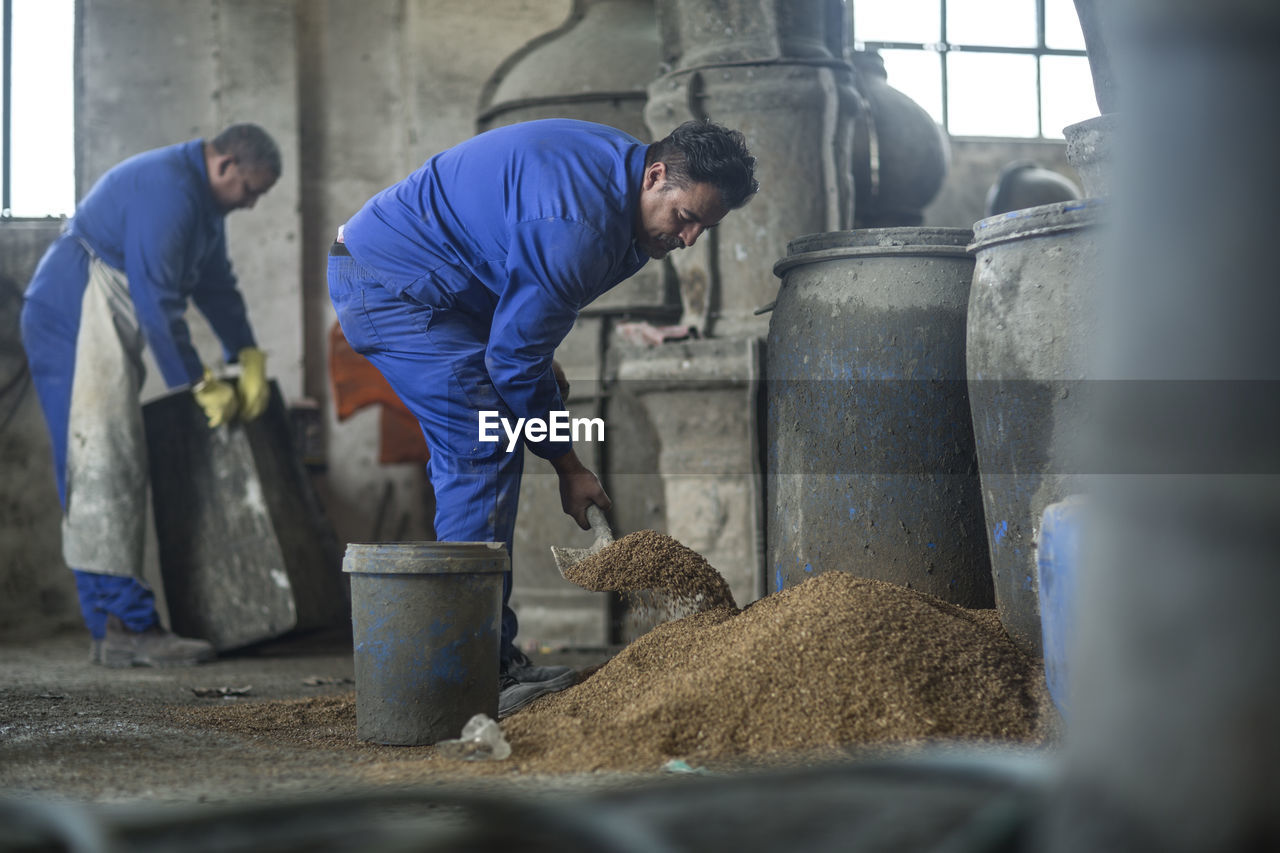 Two men working in industrial pot factory