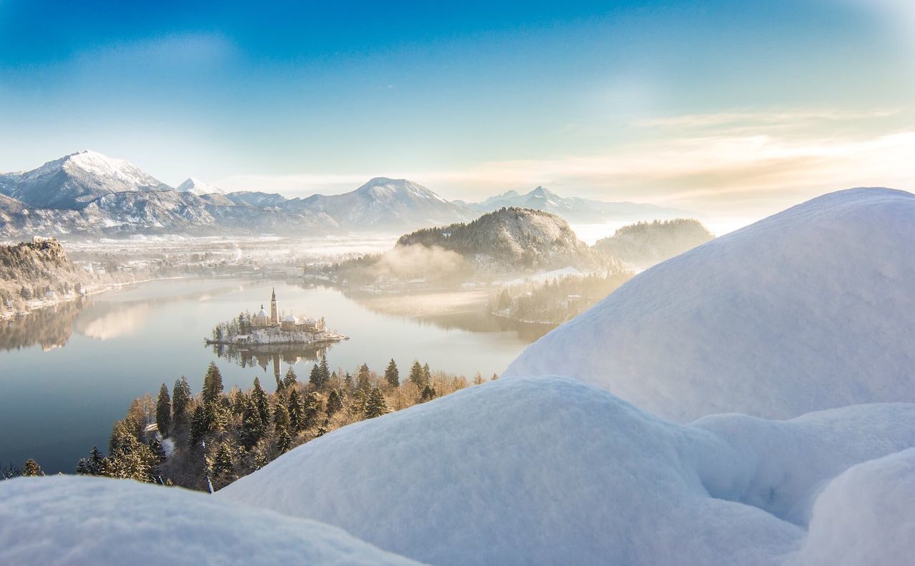 Scenic view of snow covered mountains against sky at sunset