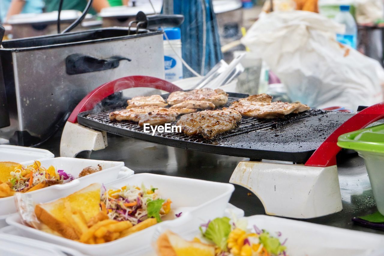 Meat cooking on barbecue grill in market