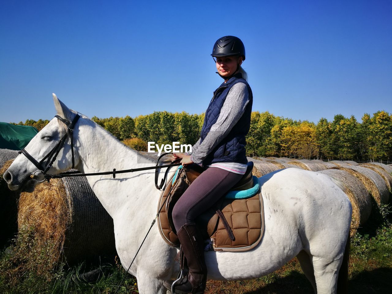 Side view of woman sitting on horse