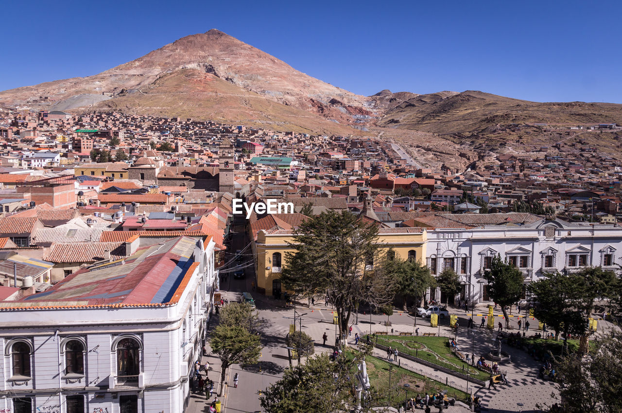 HIGH ANGLE VIEW OF BUILDINGS IN TOWN AGAINST SKY