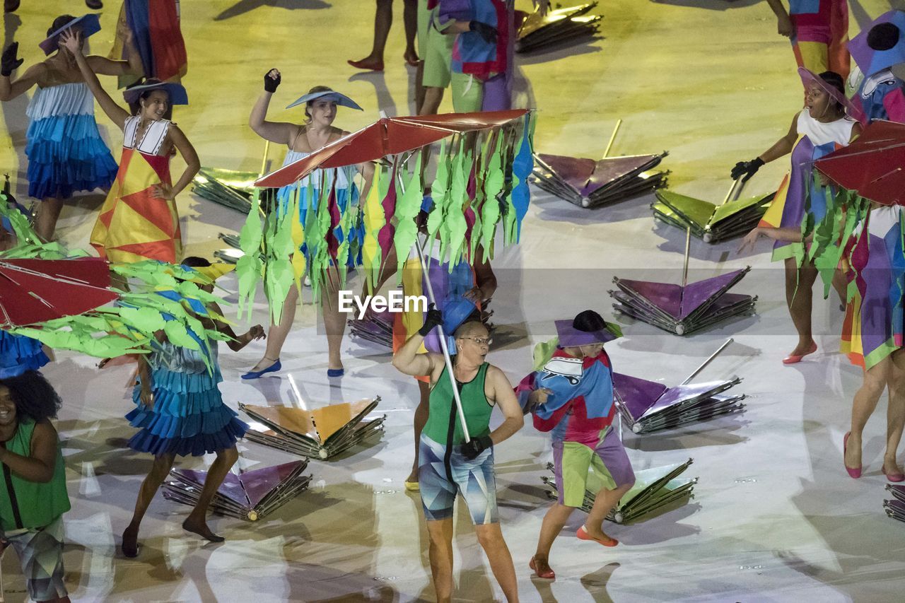 LOW SECTION OF PEOPLE STANDING IN MULTI COLORED UMBRELLAS