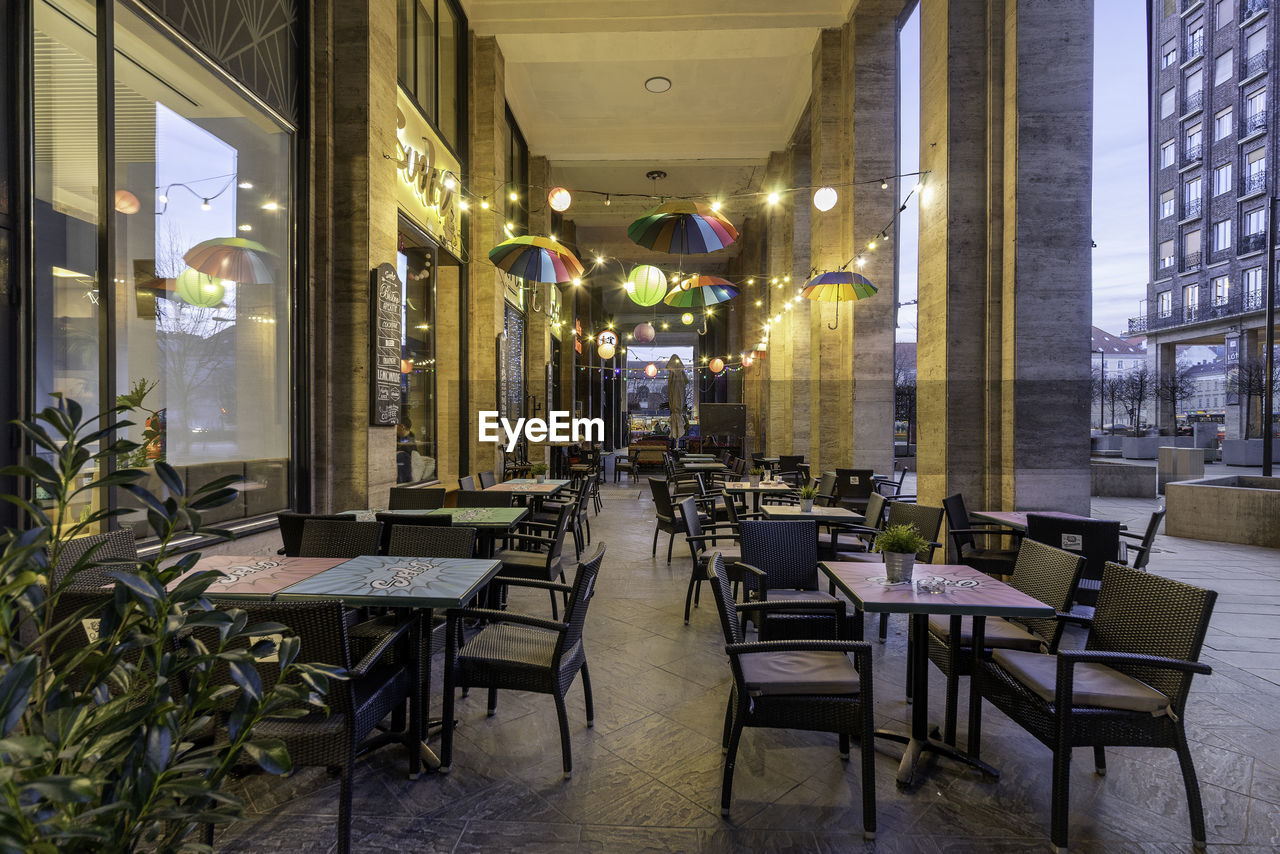 EMPTY CHAIRS AND TABLES IN BUILDING