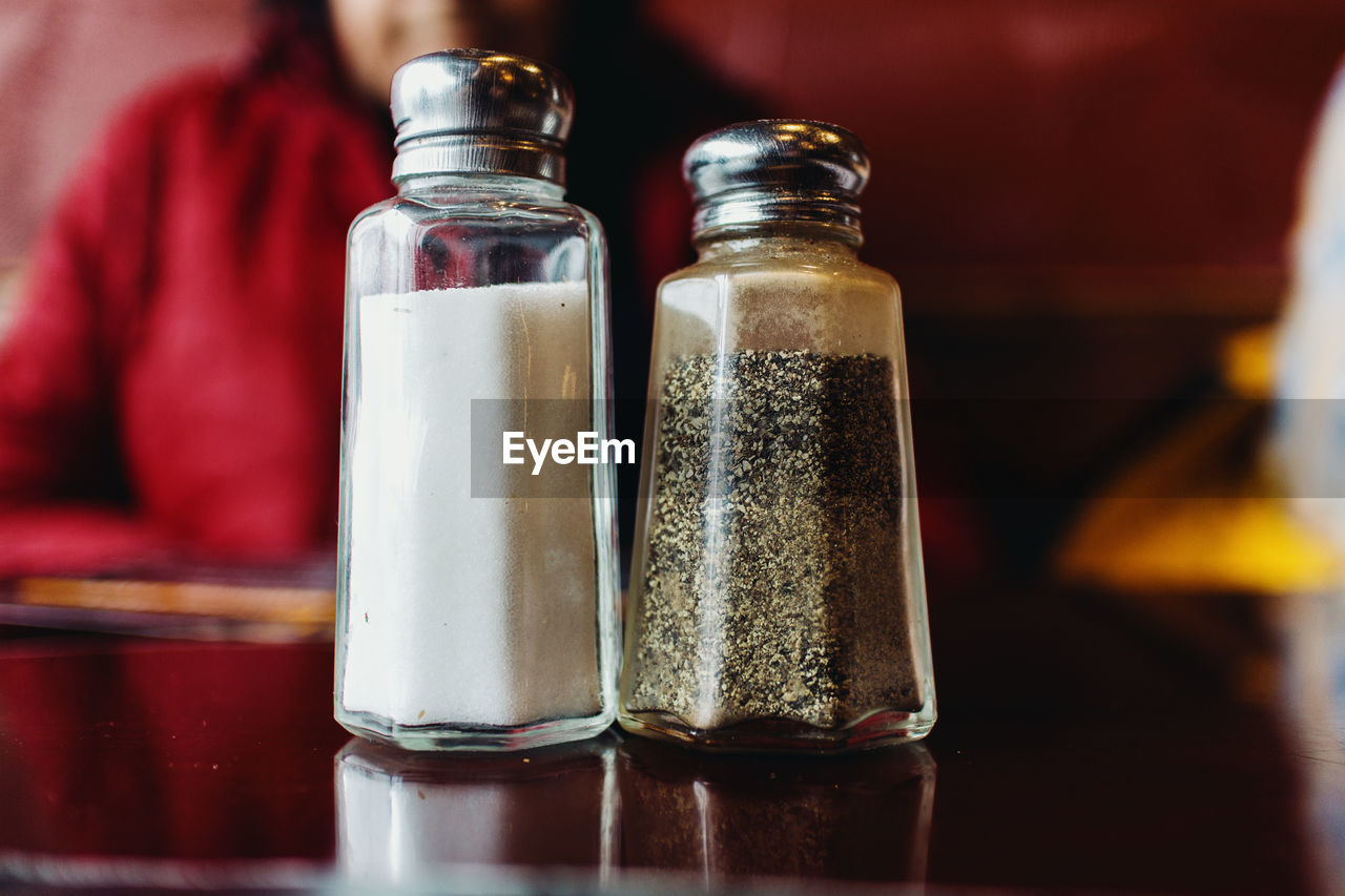 Salt and pepper shakers on restaurant table.