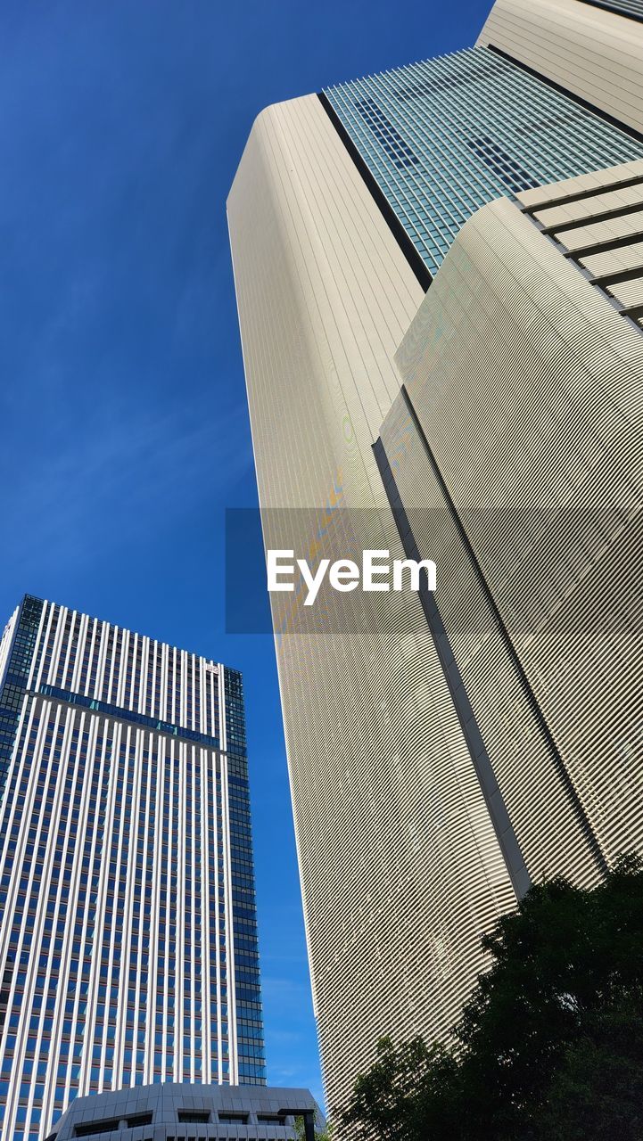 architecture, built structure, building exterior, city, building, sky, skyscraper, office building exterior, office, tower block, low angle view, business, landmark, facade, nature, headquarters, blue, no people, day, glass, outdoors, finance, metropolitan area, tower, clear sky, commercial building, roof, sunlight, corporate headquarters, downtown