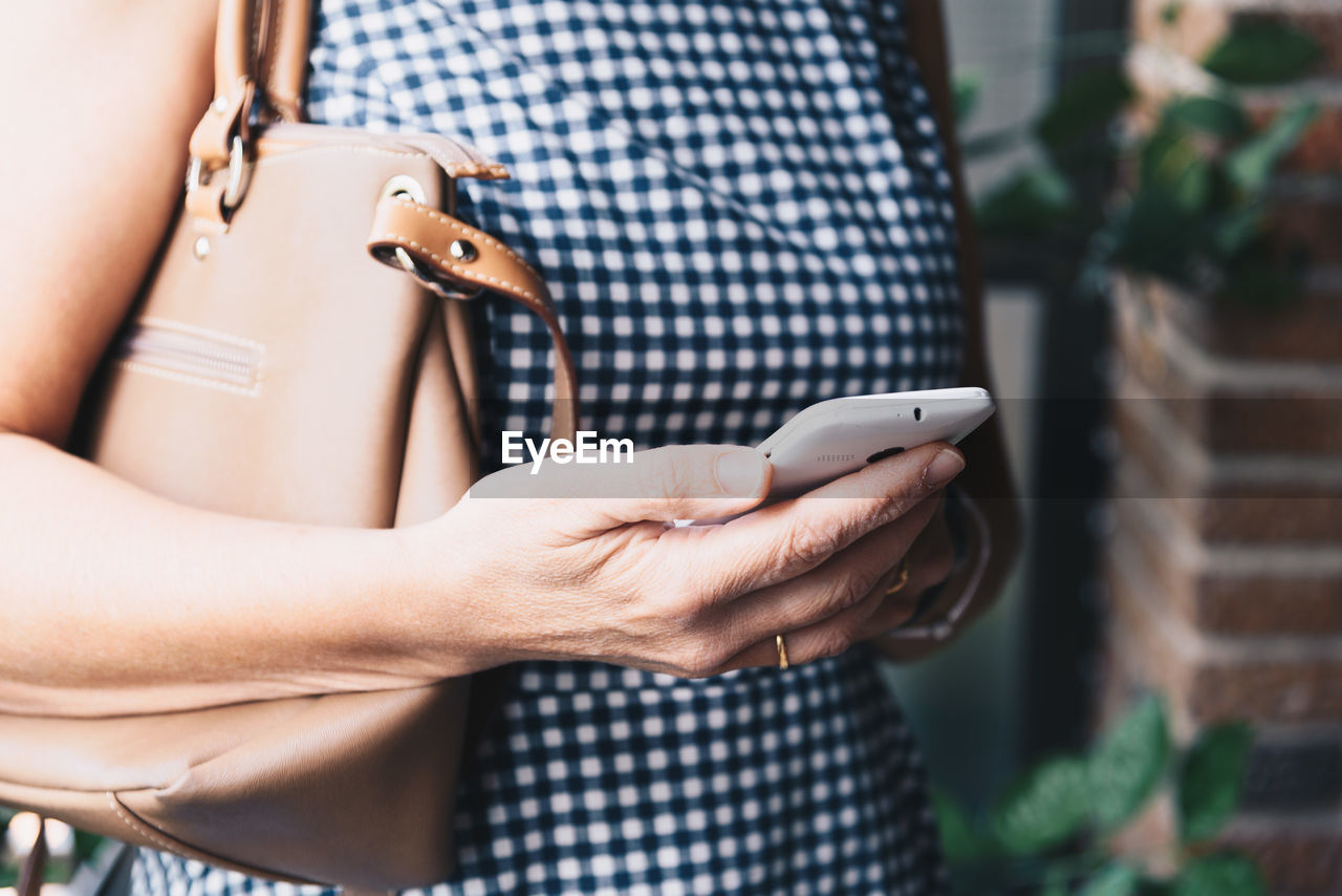 Midsection of woman holding smart phone