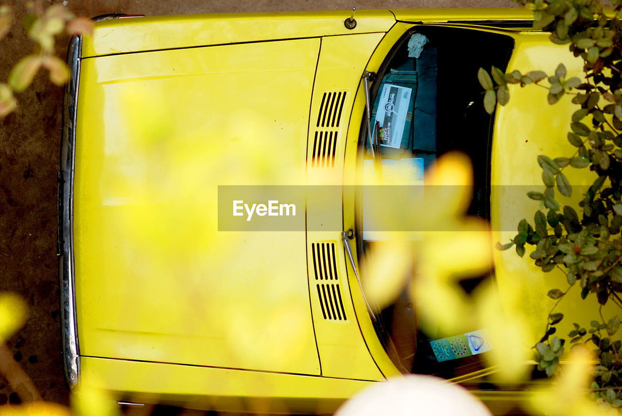 Directly above shot of yellow car in parking lot