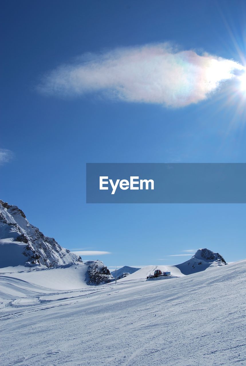 SNOW COVERED LANDSCAPE AGAINST BLUE SKY