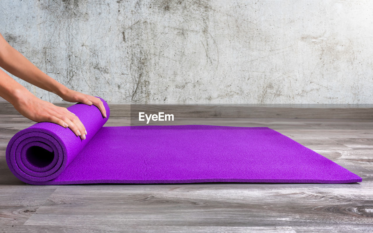 Low section of person rolling yoga mat