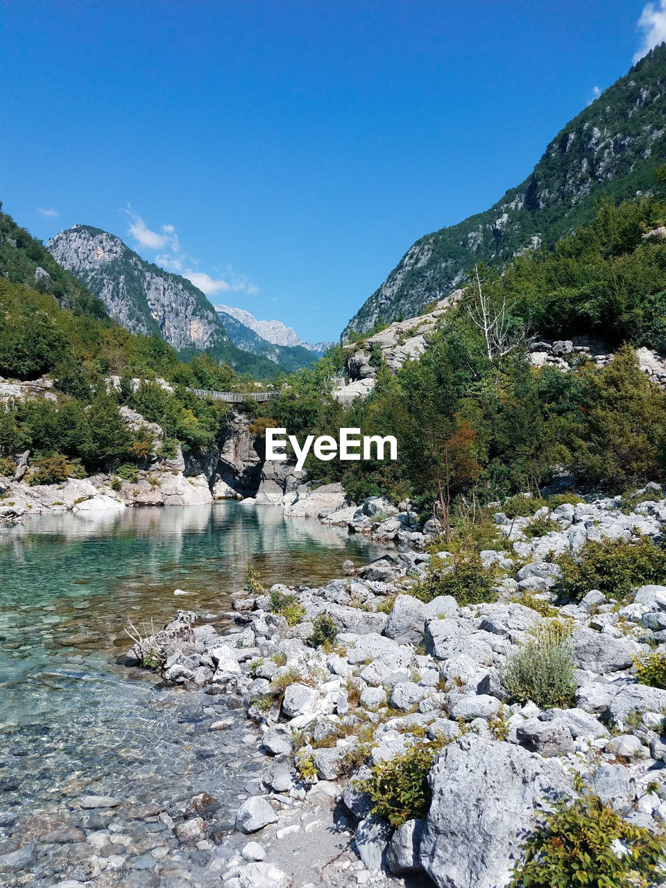 Scenic view of lake by mountains against sky