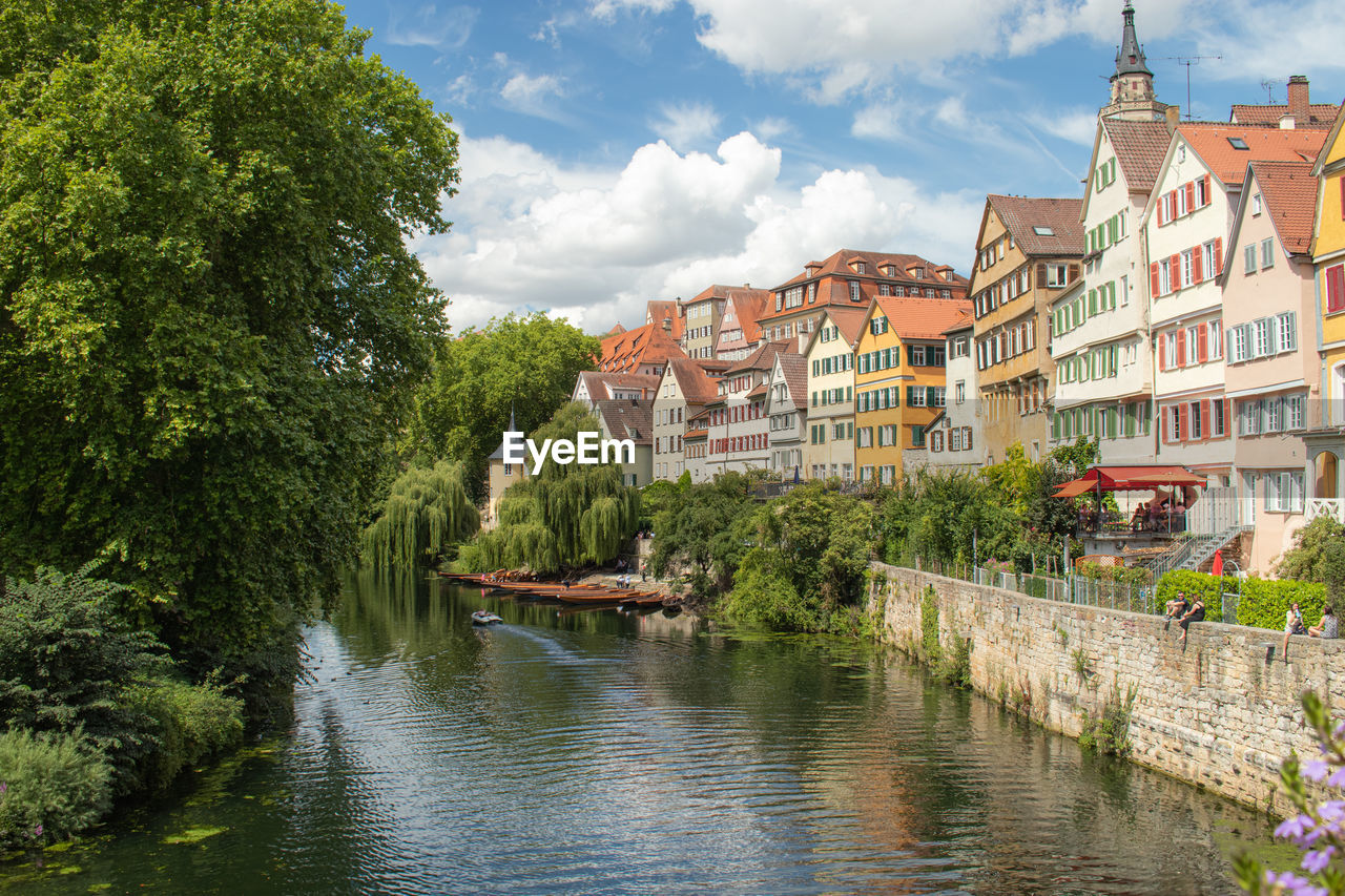 RIVER AMIDST BUILDINGS AGAINST SKY