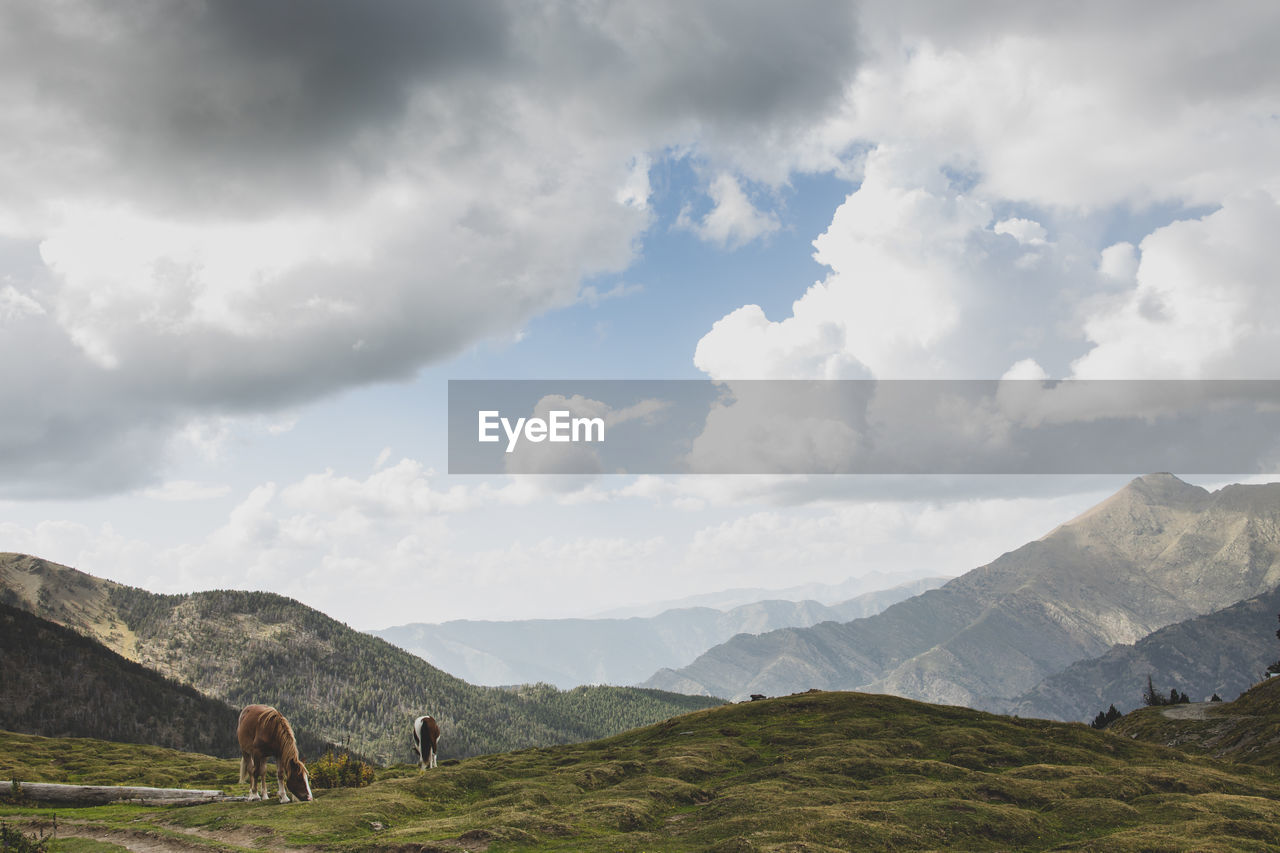 Scenic view of mountains against cloudy sky