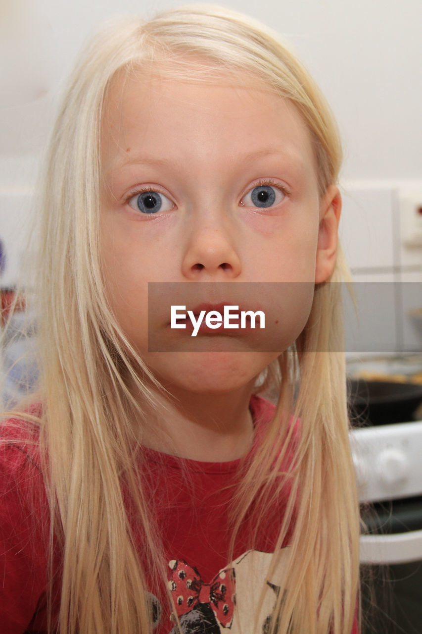 Close-up portrait of girl with raised eyebrows at home