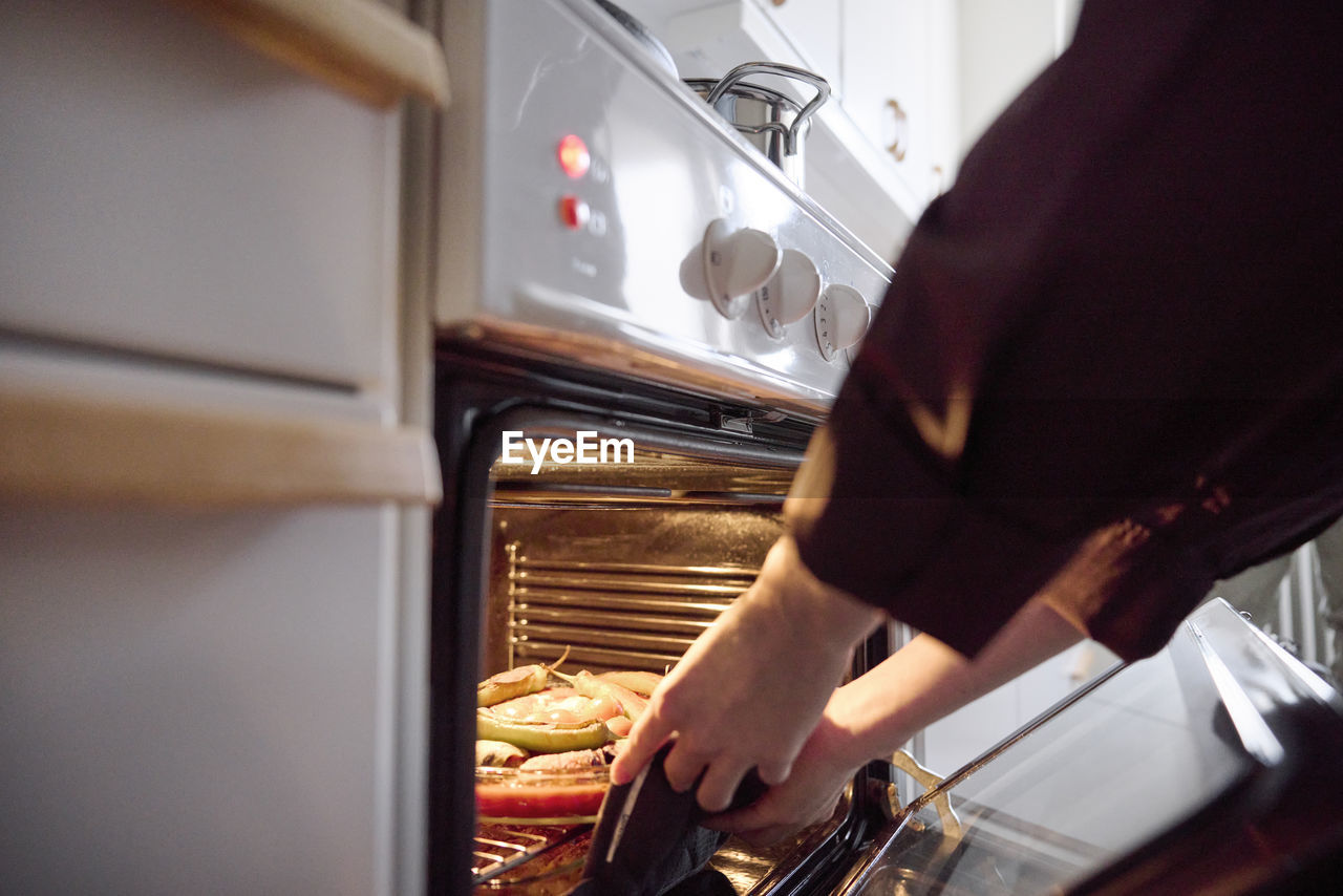 Woman taking food for eid al-fitr out of oven